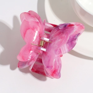 Detail view of pink marble butterfly hair claw clip with double-layer acetate texture