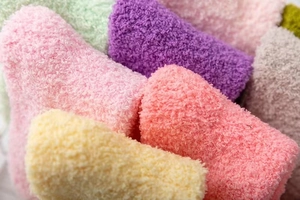 Detailed macro shot of soft coral fleece winter socks in multiple pastel colors