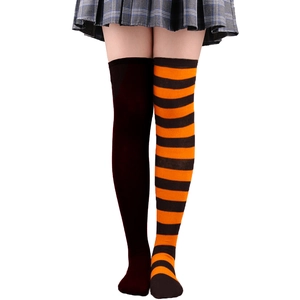 Détail de chaussettes hautes Halloween avec un design asymétrique marron et rayé orange