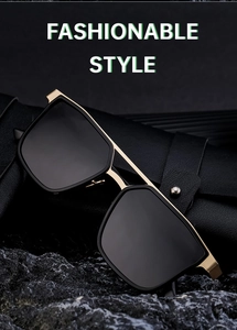 Detail view of large gold metal frame sunglasses with black lenses on black rock