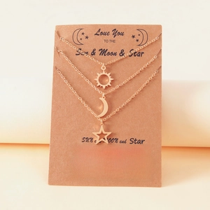 Détail des pendentifs soleil, lune et étoile sur une carte cadeau élégante