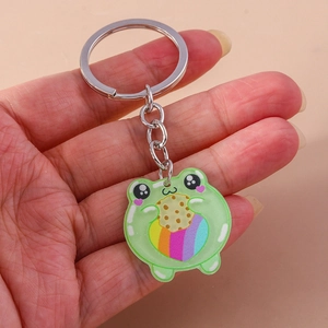 Close-up of a cute green frog acrylic keychain with rainbow detail and cookie motif