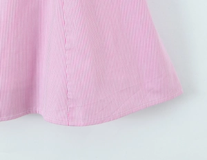 Detailed close-up of pink striped dress hem showing high-quality stitching and cotton fabric