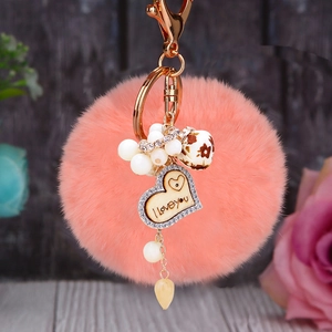 Détail d'un porte-clés en fourrure rose avec pendentif en forme de cœur doré