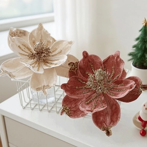 Close-up of velvet magnolia Christmas flowers in cream and red with golden glitter details