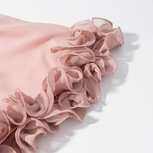 Detail of layered ruffles on a dusty pink chiffon vacation outfit with fine stitching