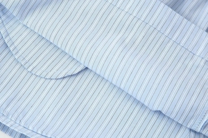 Detailed macro view of the light blue striped cotton blend fabric and fine stitching