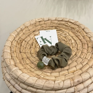 Elegante elastico scrunchie in raso verde oliva con perla decorativa ed etichetta