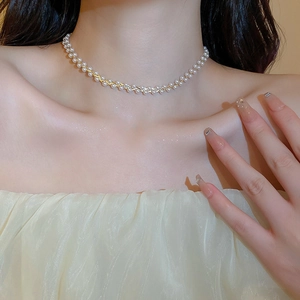 Detail der vergoldeten Kette mit weißen Perlen, elegant um den Hals gewunden