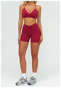Dettaglio del set yoga bordeaux con pantaloncini a vita alta a V e reggiseno sportivo