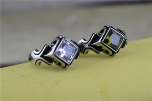 Macro shot of vintage stainless steel rings with square cut green and white gemstones