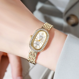 Detailed view of an elegant gold oval quartz watch with diamond-set bezel on wrist