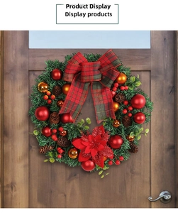 Close-up of Christmas wreath with red berries, pine cones and tartan bow on a wooden door