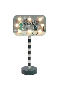 Detail of Santa Stop Here LED sign with warm bulbs and striped pole decoration