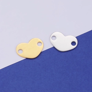 Detailed view of gold and silver heart pendants with double holes for DIY jewelry