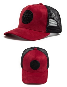 Detail view of red faux suede baseball cap with black mesh back and circular leather patch