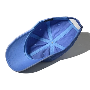 Detailed interior of blue cotton baseball cap showing 6-panel stitching and sweatband