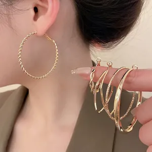 Set of minimalist gold textured earrings featuring braided and geometric ring designs