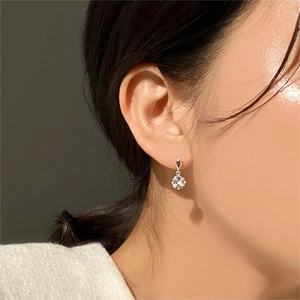 Side view of model wearing silver teardrop earring with round zircon stone