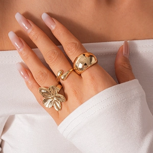 Three-piece gold geometric ring set with floral and smooth metal designs for women