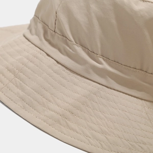 Macro detail of multi-row stitching on brim of light khaki outdoor sun hat fabric