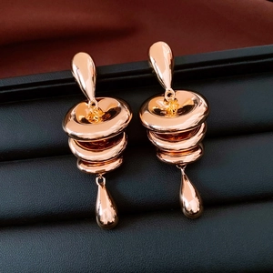 Detailaufnahme von roségoldenen Ohrhänger mit gestuften runden Akzenten und Tropfen