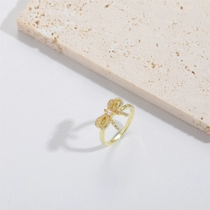 Elegant gold bow ring with yellow gemstones on stone prop, adjustable open style for women
