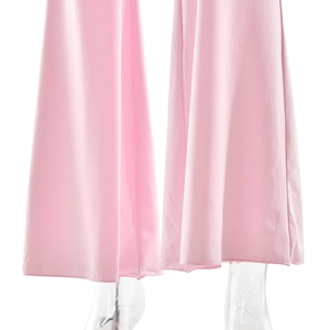 Gros plan détaillé de l'ourlet évasé du pantalon rose avec un beau drapé de tissu
