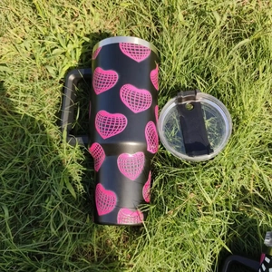 Detail of 40oz car tumbler with disco heart pattern on green lawn in sunlight