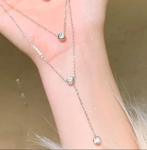 Detail of a minimalist double-layered titanium steel necklace with sparkling crystal charms