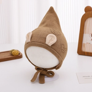 Detailed knit texture of a warm winter baby elf hat with heart pattern and ear flaps
