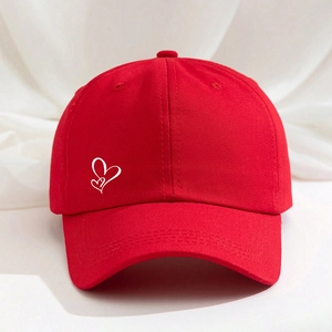Detailed close-up of a red cotton baseball cap featuring white double heart embroidery