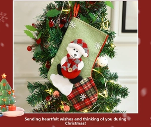 Hanging Christmas stocking with polar bear plush detail on decorative tree branch