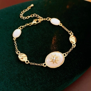Detailed shot of vintage gold bracelet with star pendant on green velvet
