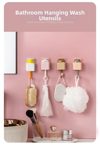 Detail of cartoon animal wall hooks hanging bath brushes on a pink bathroom wall
