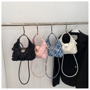 Detail of four quilted canvas crossbody bags in black pink blue and white on hangers