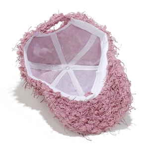 Vue détaillée de l'intérieur d'une casquette en peluche rose avec coutures blanches
