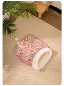 Detailed macro view of plush pink cat sleeping bag with soft fleece lining and pompom
