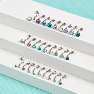 G23 titanium curved eyebrow rings with colorful opal and zircon inlays on blue background