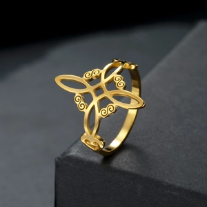 Polished gold Celtic knot stainless steel ring on elegant black stone pedestal