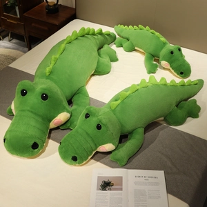 Ensemble de peluches crocodile vert en trois tailles sur un lit pour décoration