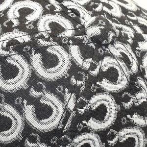 Macro shot of high-density black and white jacquard weave pattern on a baseball cap