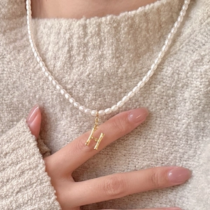 French retro pearl necklace with golden bamboo texture H letter pendant on a model