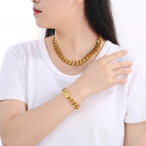 Detailed view of model wearing a 13mm 18K gold plated Cuban chain necklace and bracelet set