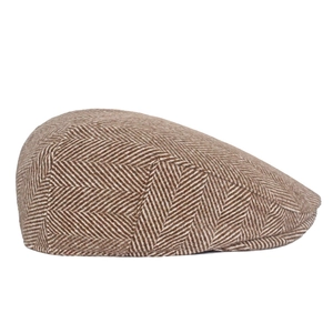 Detail of classic brown herringbone wool tweed fabric on a vintage newsboy flat cap