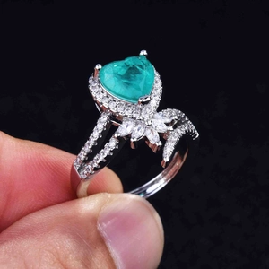 Macro view of pear-shaped emerald ring featuring micro-pave setting on the band