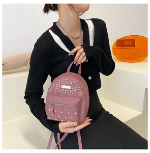 Close-up of mini punk rivet backpack in lotus pink faux leather with gold studs