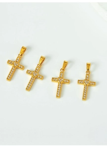 Macro shot of gold cross pendants with micro-pave zircons and center heart detail