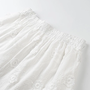 Close-up of white cotton set featuring 3D floral embroidery and elastic pleated waist