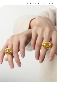 Detailed view of 18K gold plated titanium steel rings with polished sphere and drop shapes